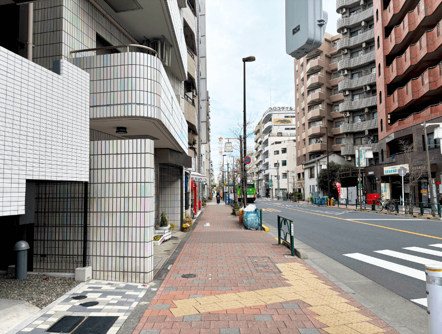 坂を下り、右側の横断歩道を渡り直進します。