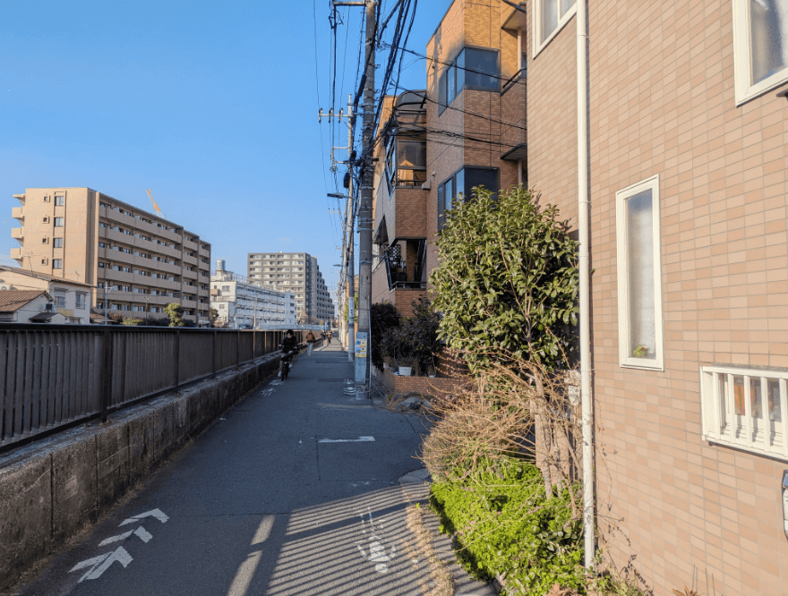 右手に橙色のマンションが見えてきたら、右折し、線路に突き当たるまで歩きます。