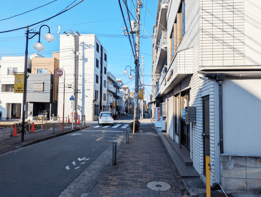 白いマンションが左手に見えてきたら、右折し橋に向かって直進します。