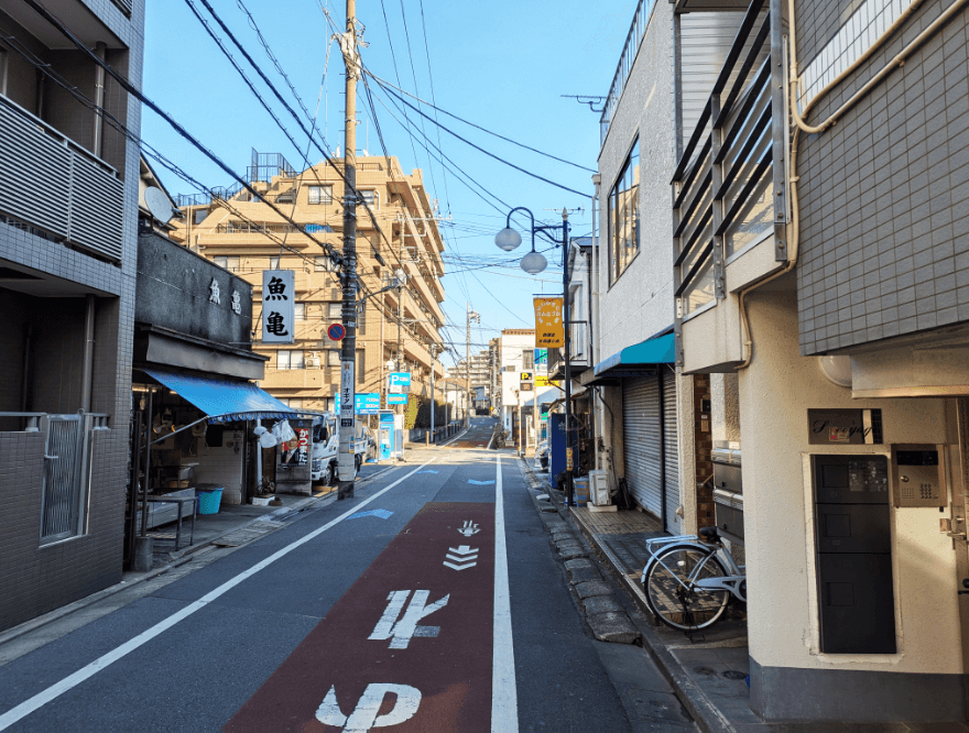 白いマンションが左手に見えてきたら、右折し橋に向かって直進します。