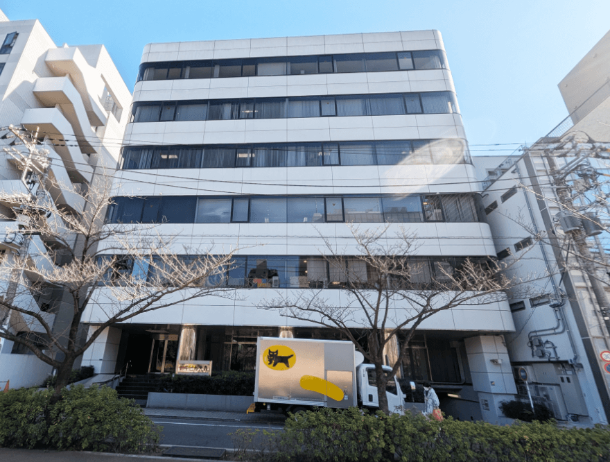 左手にベンチが見えてきます。右手にあるビルの２階にお越しください。