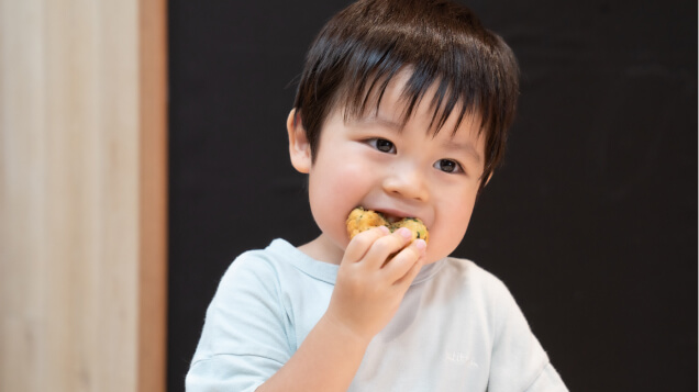 子どもが手作りおやつを食べている写真